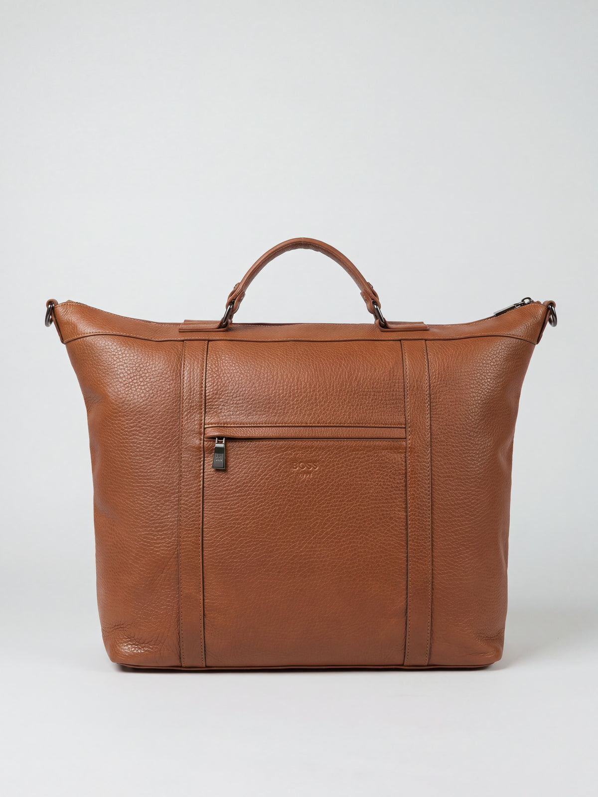 Alessio cognac pebble-grain leather travel bag by Clemés, front view with top handle and front zip pocket
