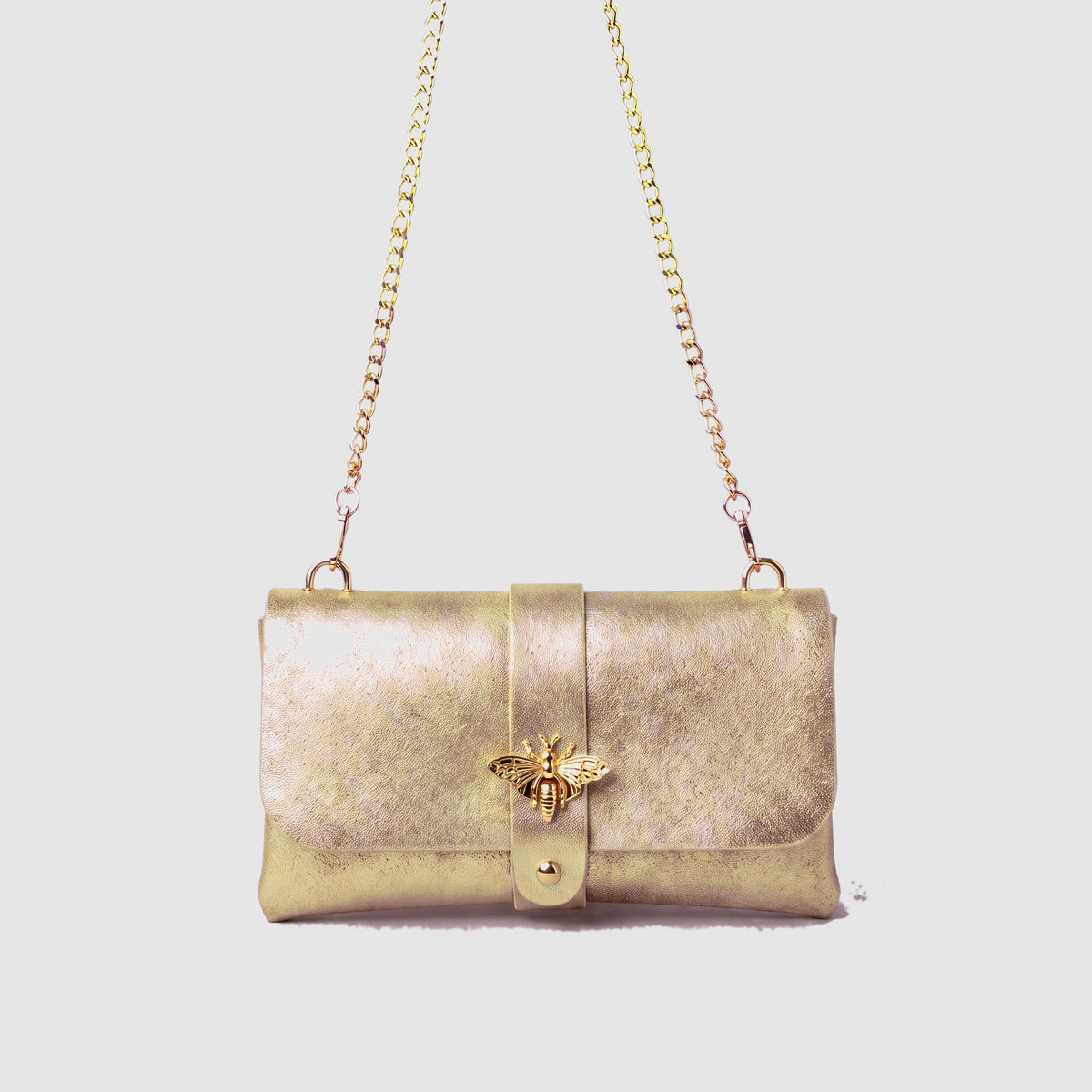 Anima Suede Leather Metallic Clutch Shoulder Bag by Clemés in Champagne, studio shot on grey background