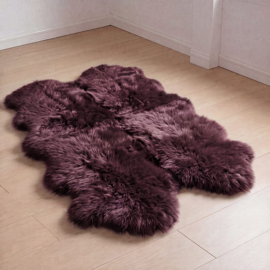 Aubergine quad sheepskin rug laid on a light wood floor