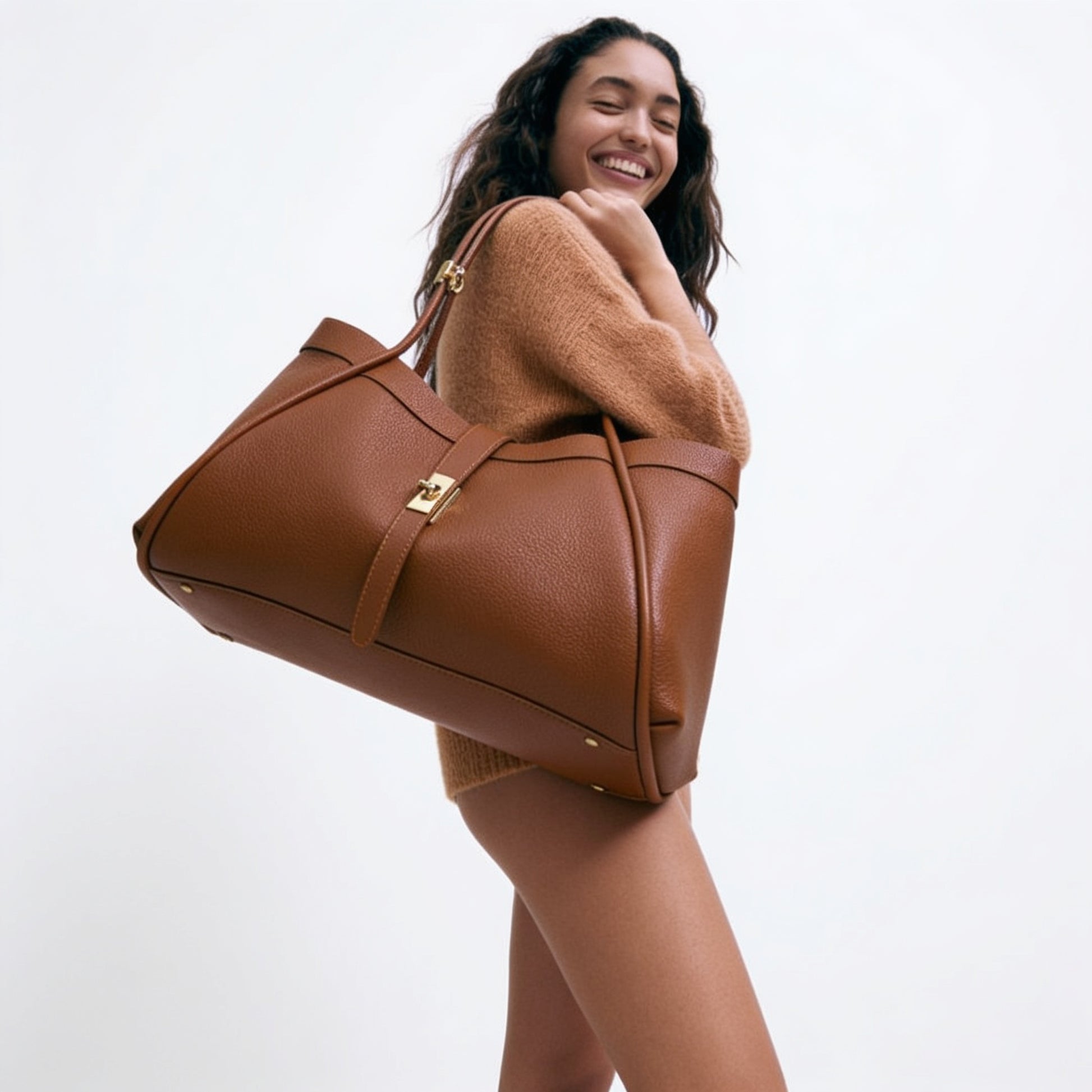 Model carrying the Dark Tan Bianca Large Leather Handbag by Clemés on her shoulder, studio shot