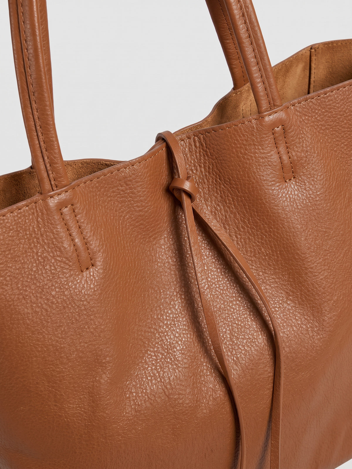 Carlotta oversized leather tote by Clemés in Dark Tan leather, close-up of the top edge with rolled handles and knotted leather tie