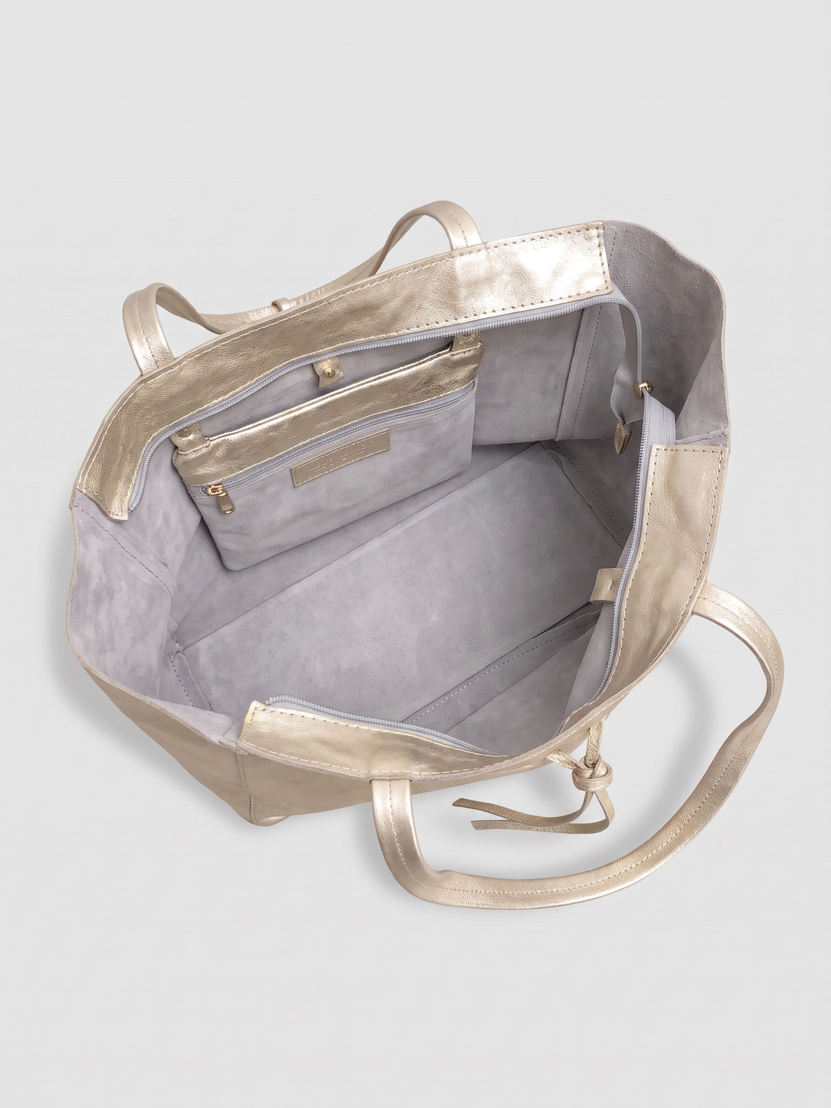 Carlotta oversized leather tote by Clemés in Champagne Gold metallic leather, interior view showing the light grey suede lining and zip pocket