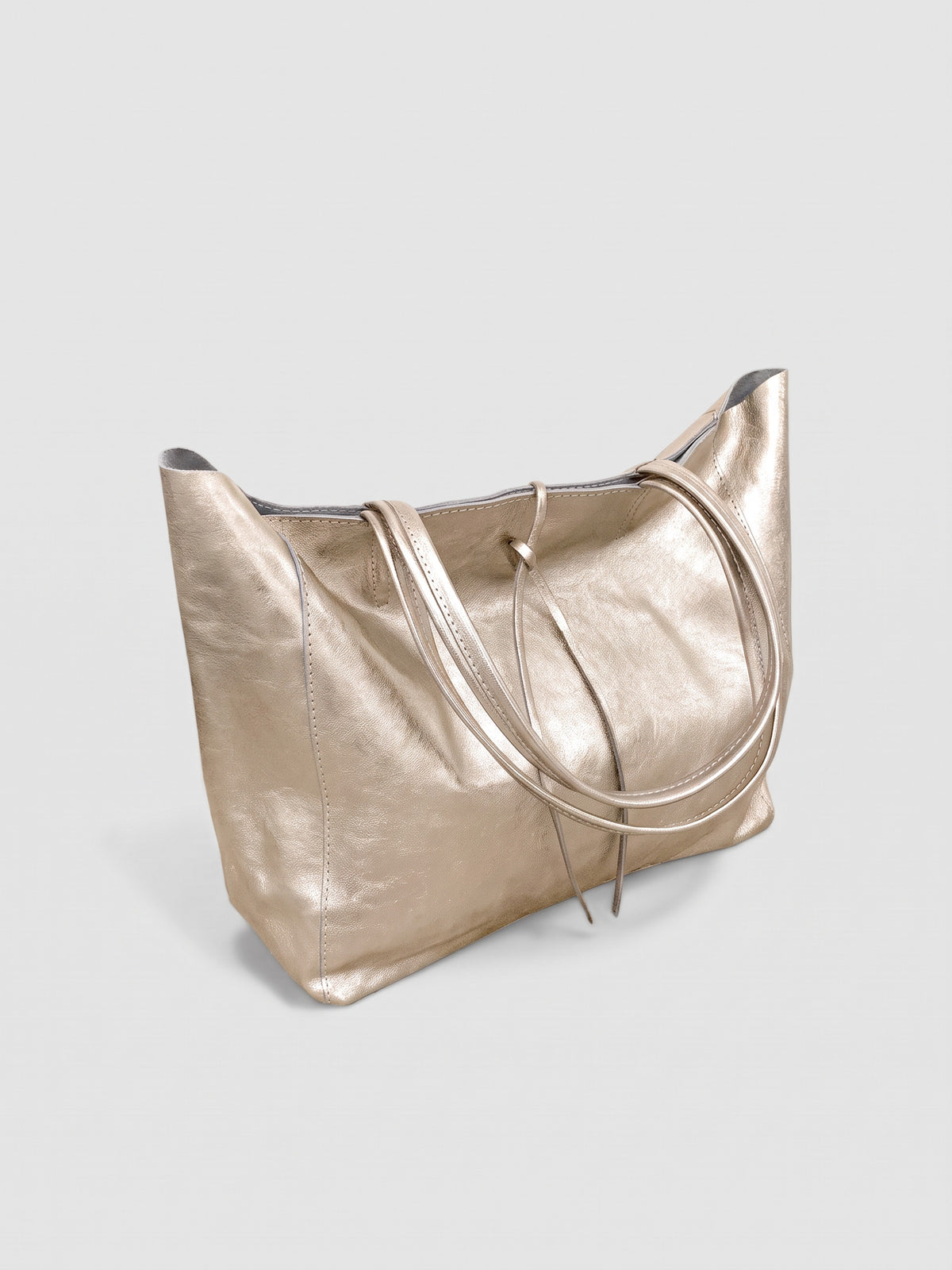 Carlotta oversized leather tote by Clemés in Champagne Gold metallic leather, three-quarter studio view