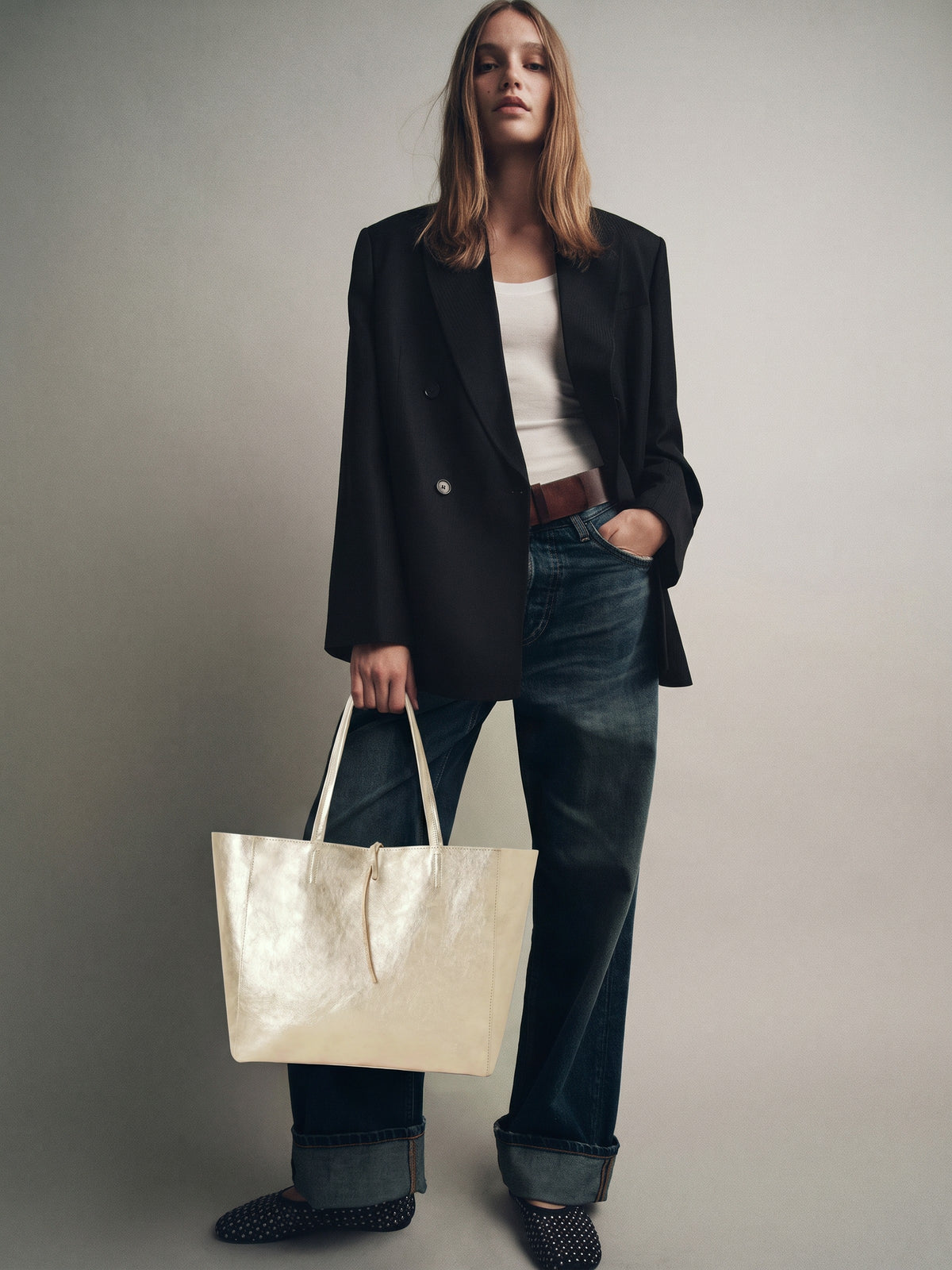 Carlotta oversized leather tote by Clemés in Champagne Gold metallic leather, lifestyle shot carried by a model