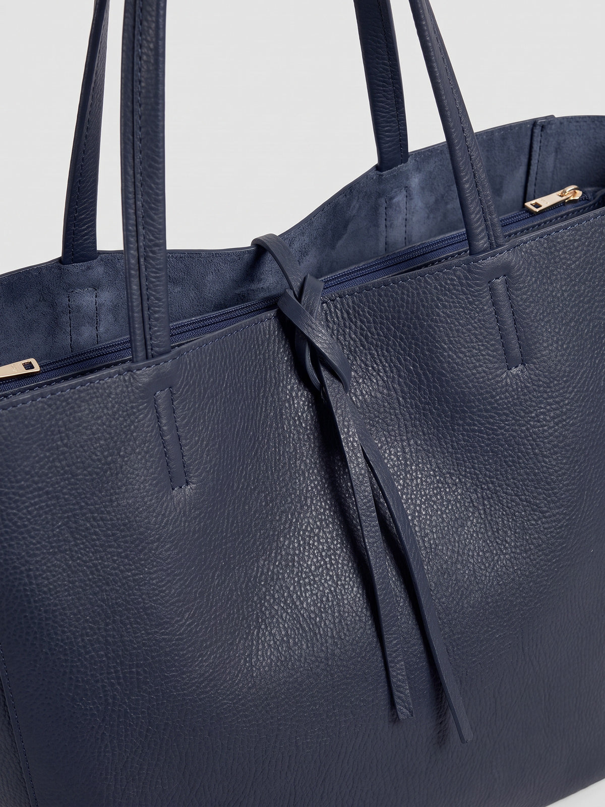 Carlotta oversized leather tote by Clemés in Navy leather, close-up of the top edge with rolled handles and knotted leather tie