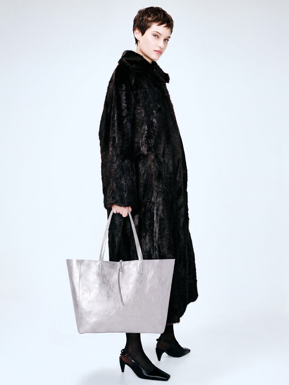 Carlotta oversized leather tote by Clemés in Silver metallic leather, lifestyle shot carried by a model
