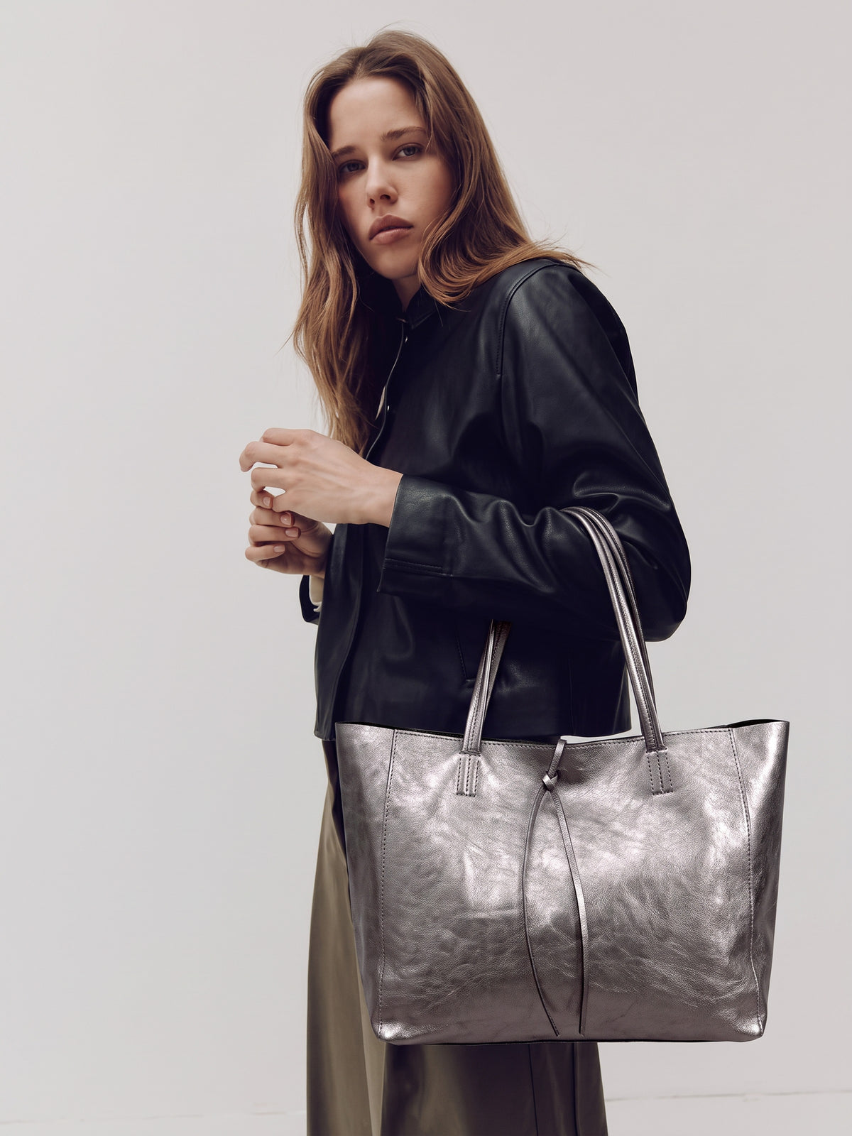Carlotta oversized leather tote by Clemés in Titanium metallic leather, lifestyle shot carried by a model