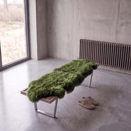 Meadow double New Zealand sheepskin rug and throw laid on a bench in a minimalist room