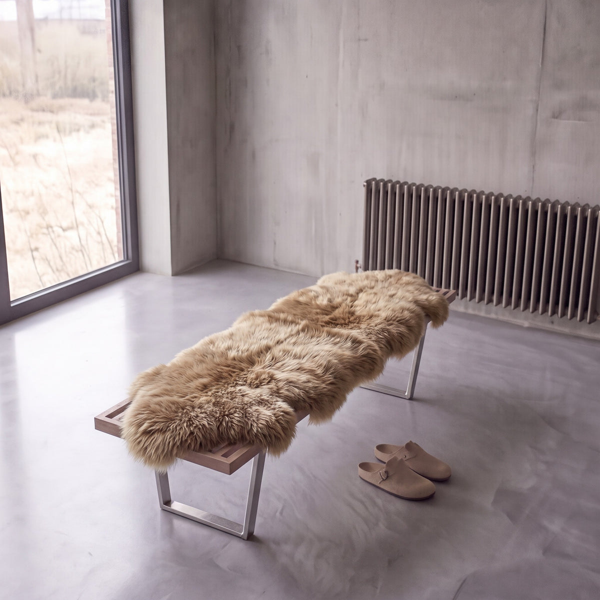 Honey double New Zealand sheepskin rug and throw laid on a bench in a minimalist room
