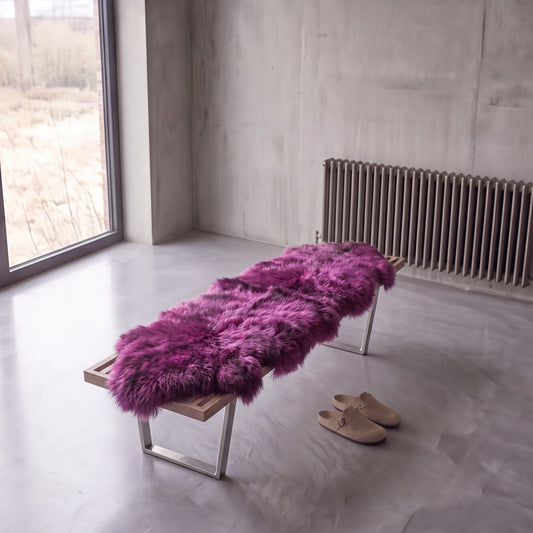 Medici double New Zealand sheepskin rug and throw laid on a bench in a minimalist room