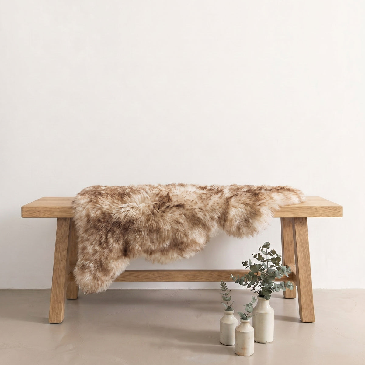 Eclipse sheepskin rug draped over an oak bench