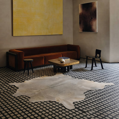 Pale grey cowhide rug in a moody tile-floor living room