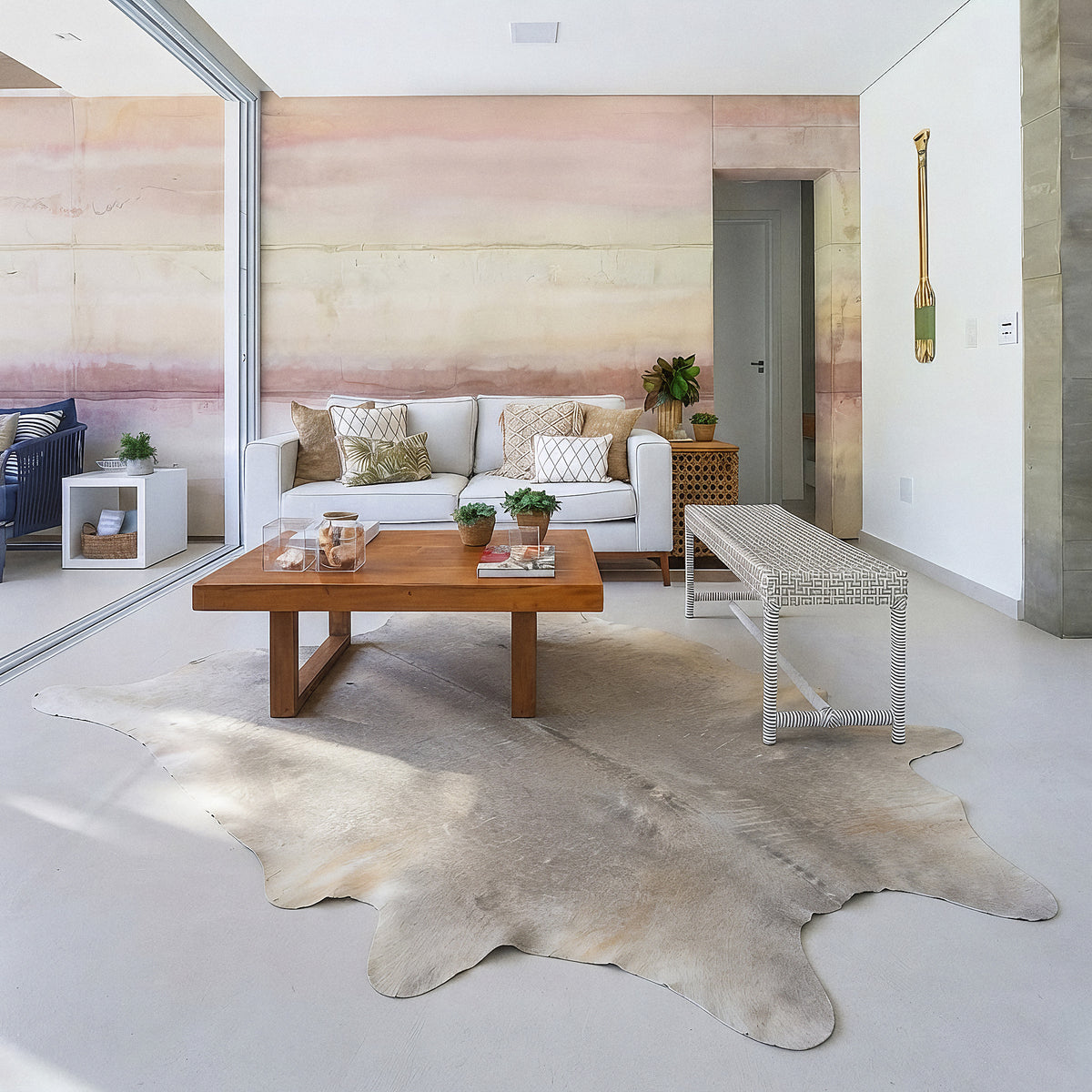 Pale grey cowhide rug in a soft blush-pink living room