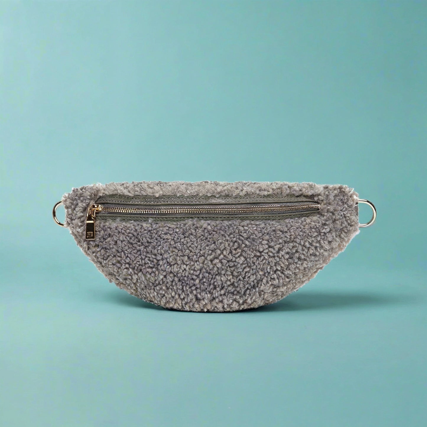 Nevina shearling and leather bum bag in Dover grey on a teal studio background