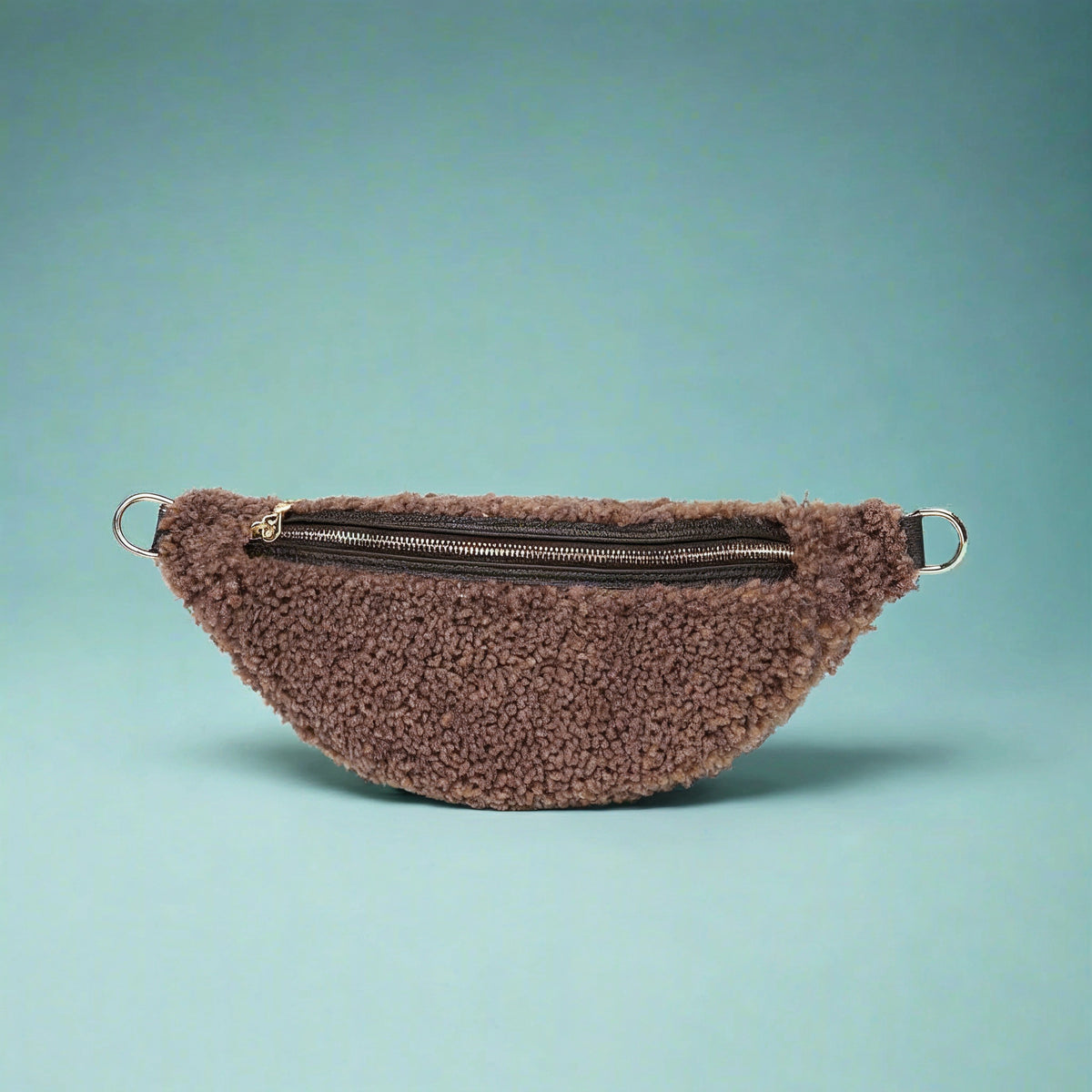 Nevina shearling and leather bum bag in taupe on a teal studio background