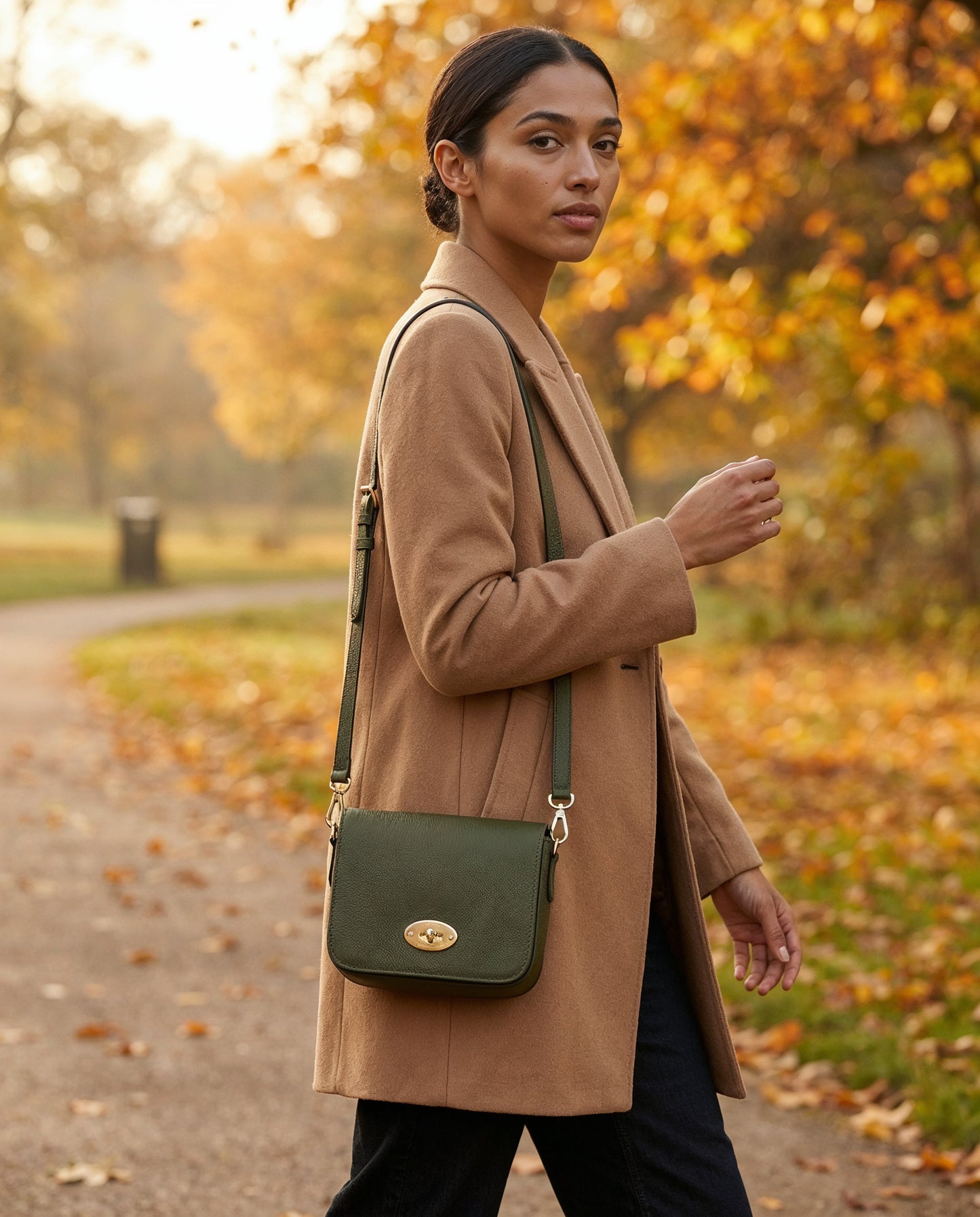 Woman carrying the Dark Olive Chiara crossbody bag in an autumn park