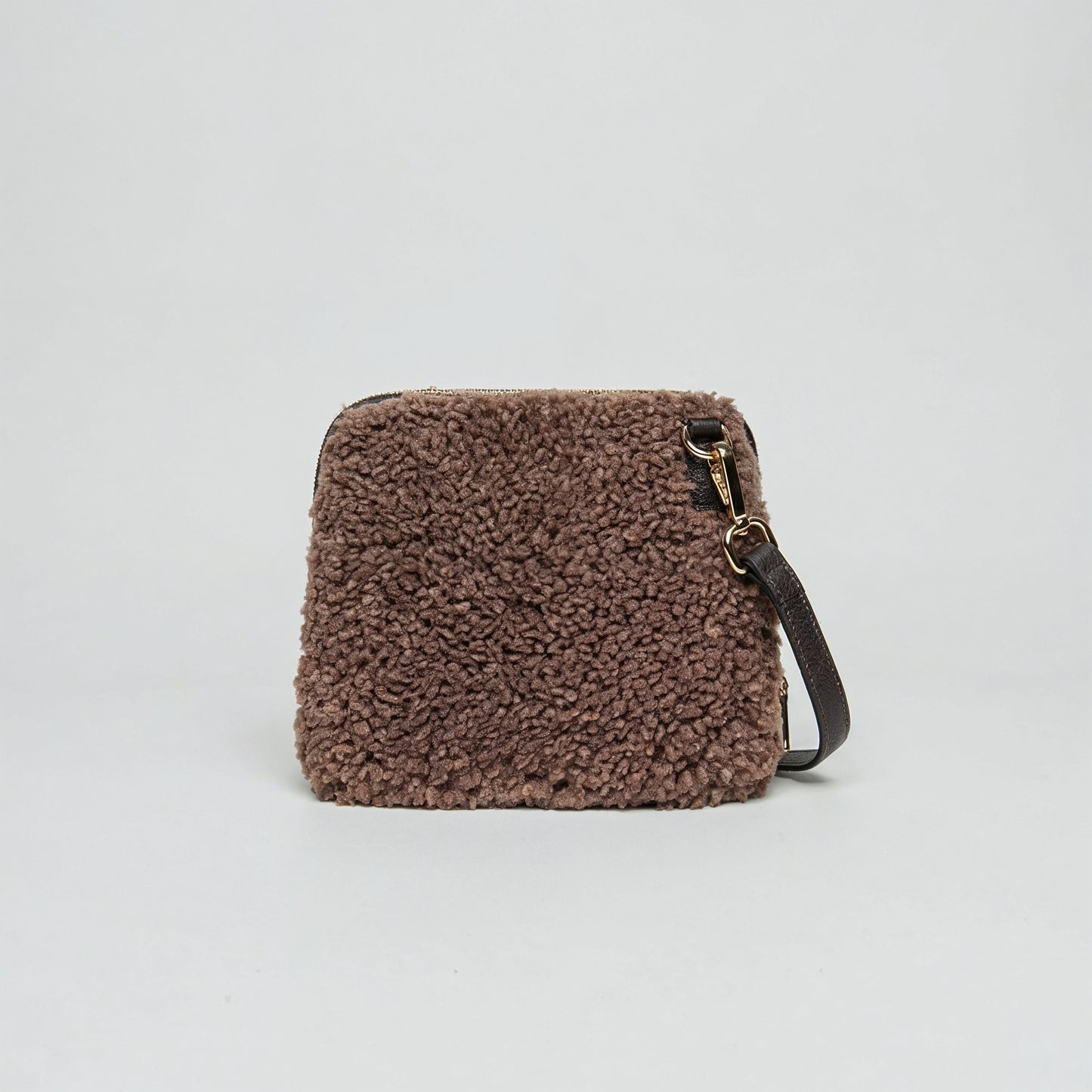 Zita faux shearling crossbody bag in tan on a light grey studio background