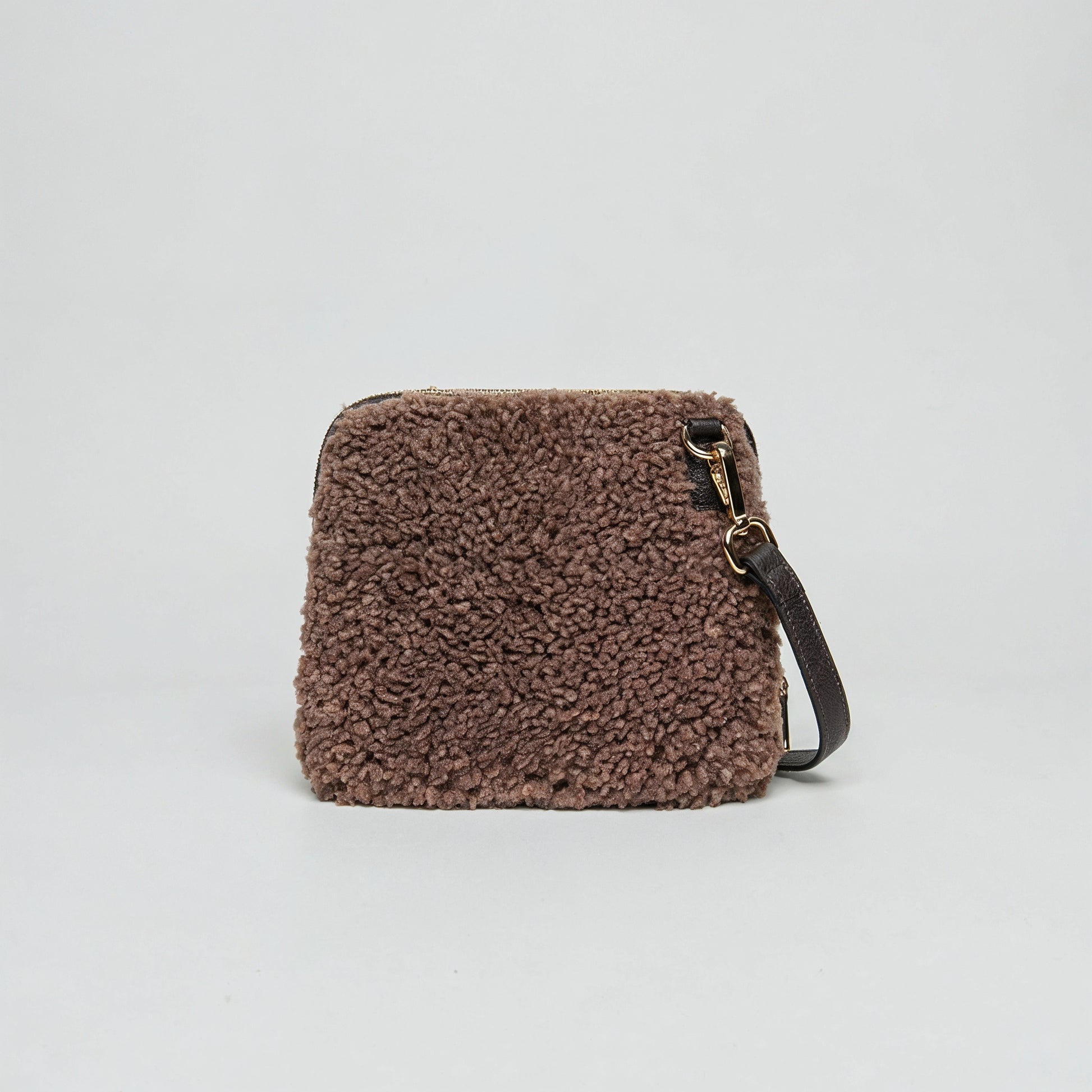Zita faux shearling crossbody bag in tan on a light grey studio background