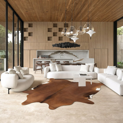 Chestnut brown cowhide rug in a living room with green velvet sofa