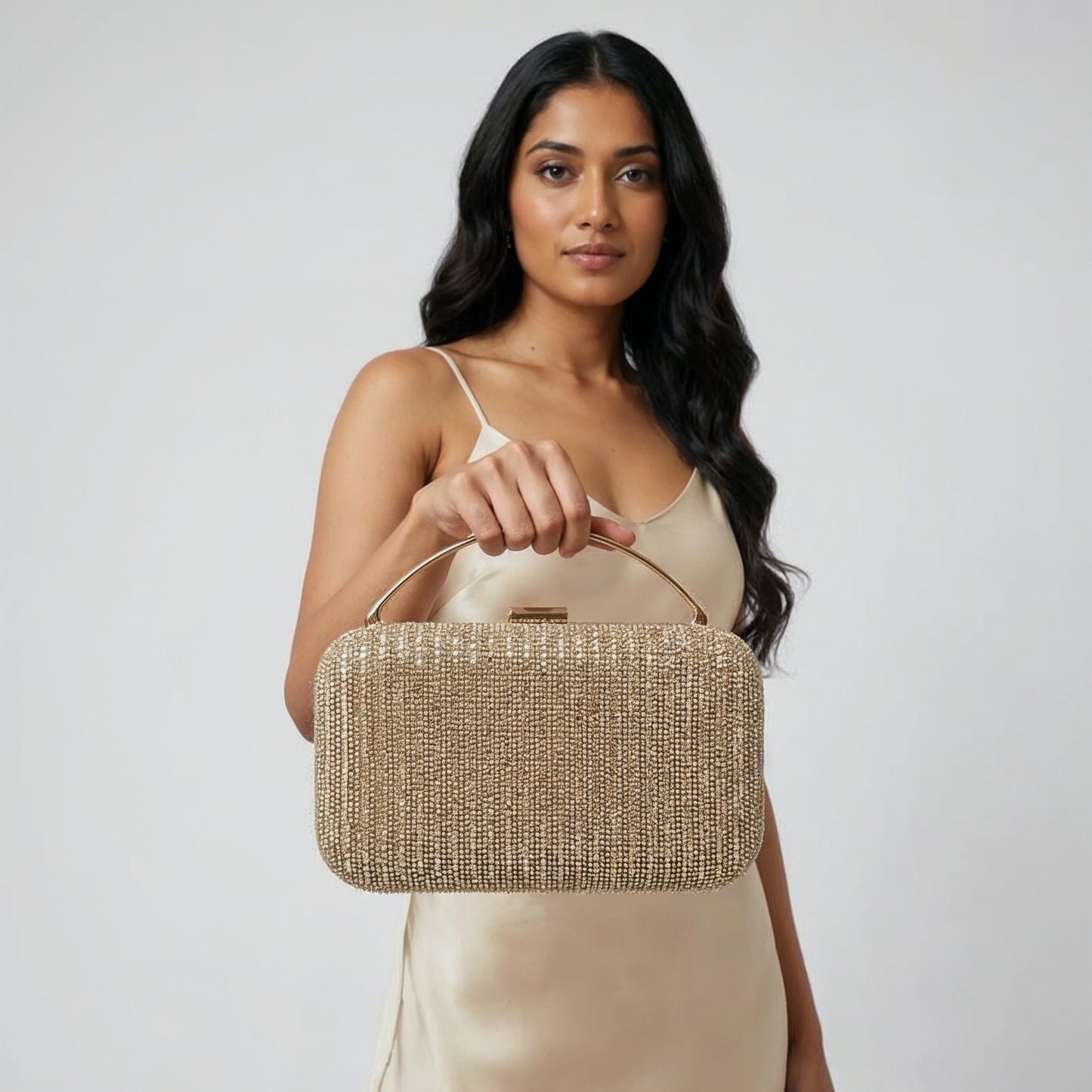 Model with the Gold Odette Crystal Minaudière Clutch dangling from her fingers, studio shot