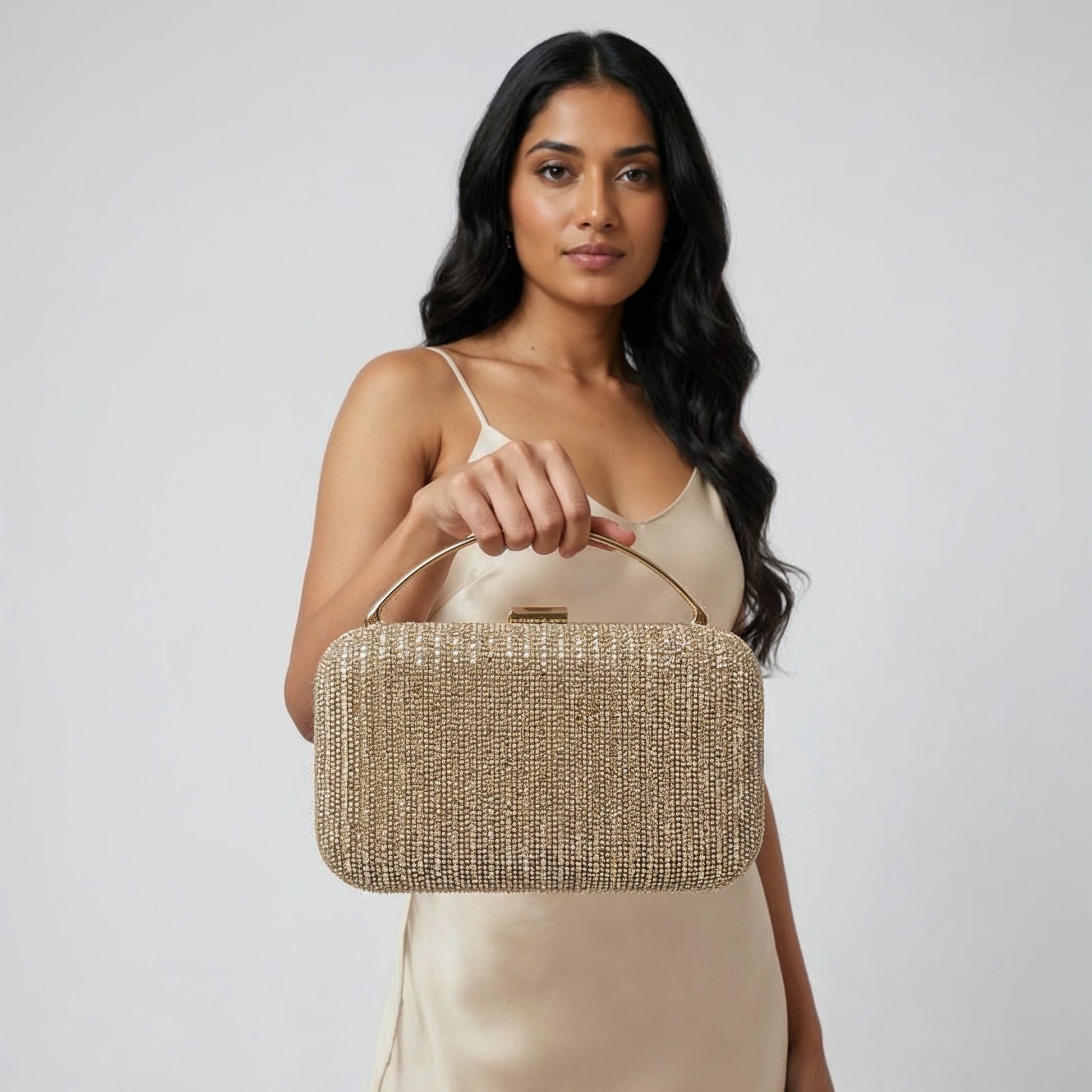 Model with the Gold Odette Crystal Minaudière Clutch dangling from her fingers, studio shot