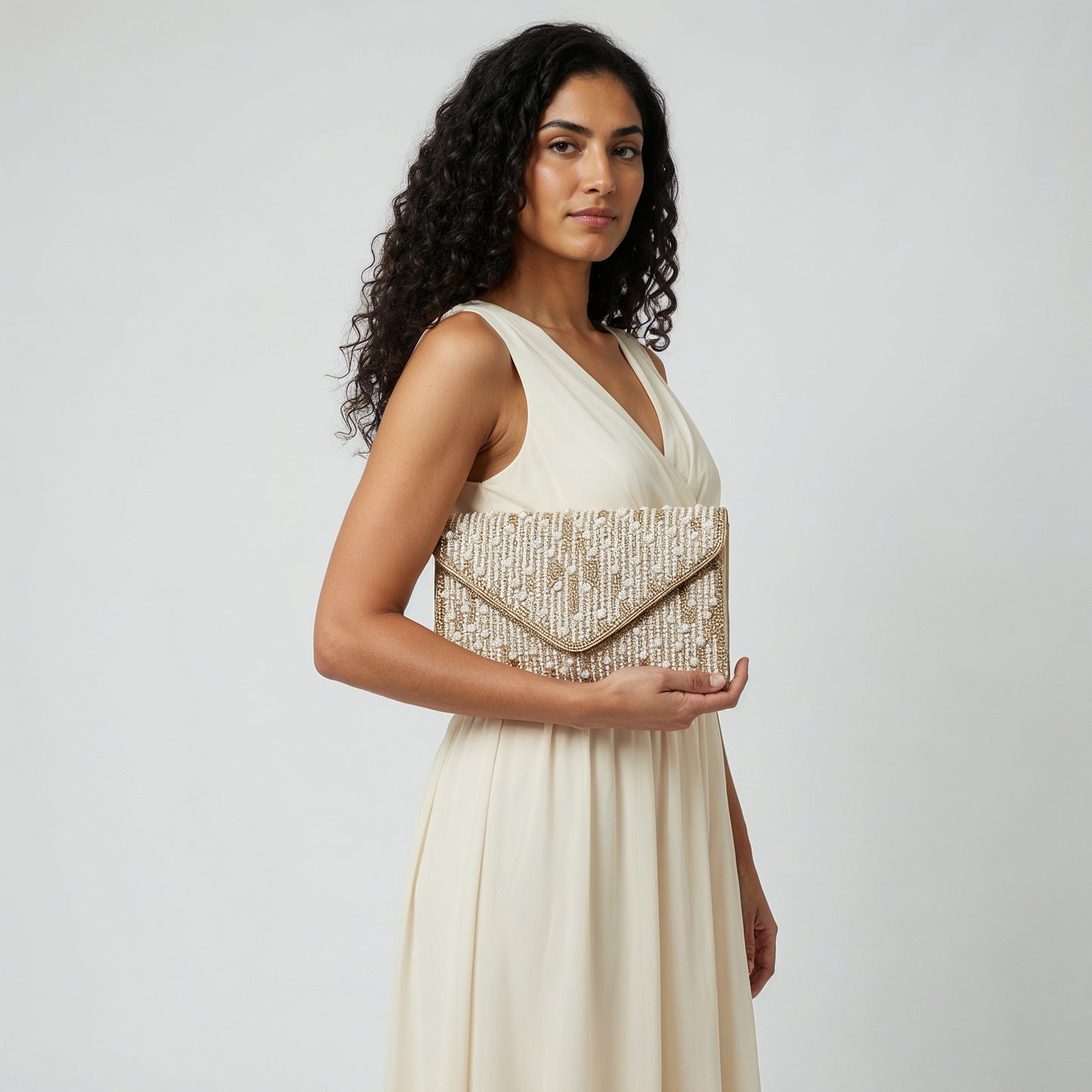 Model with the Gold Perlette Pearl & Crystal Envelope Clutch under her arm, studio shot