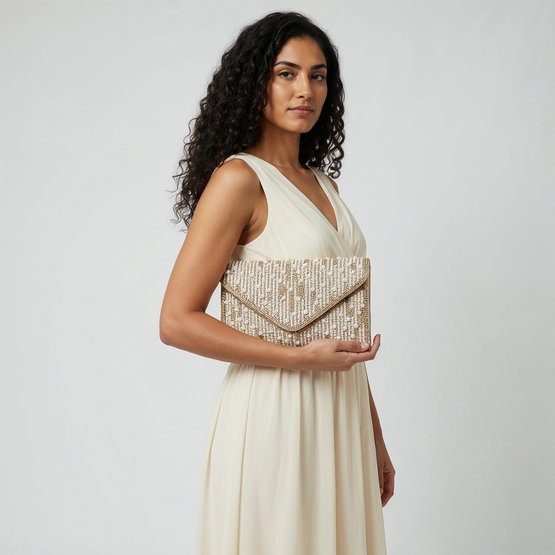 Model with the Gold Perlette Pearl & Crystal Envelope Clutch under her arm, studio shot
