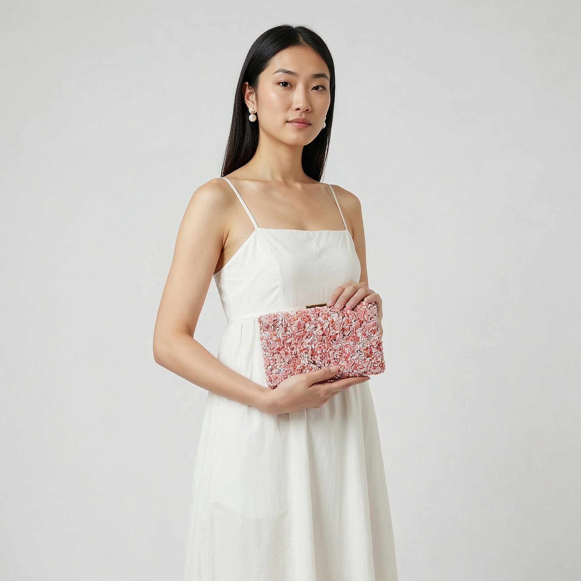 Model holding the Lilac Gemma Natural Stone Box Clutch in both hands at waist level, studio shot