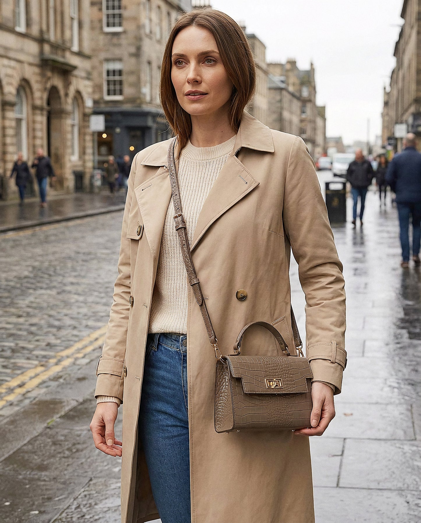 Woman with the Taupe Margot Croc crossbody bag on an overcast city street
