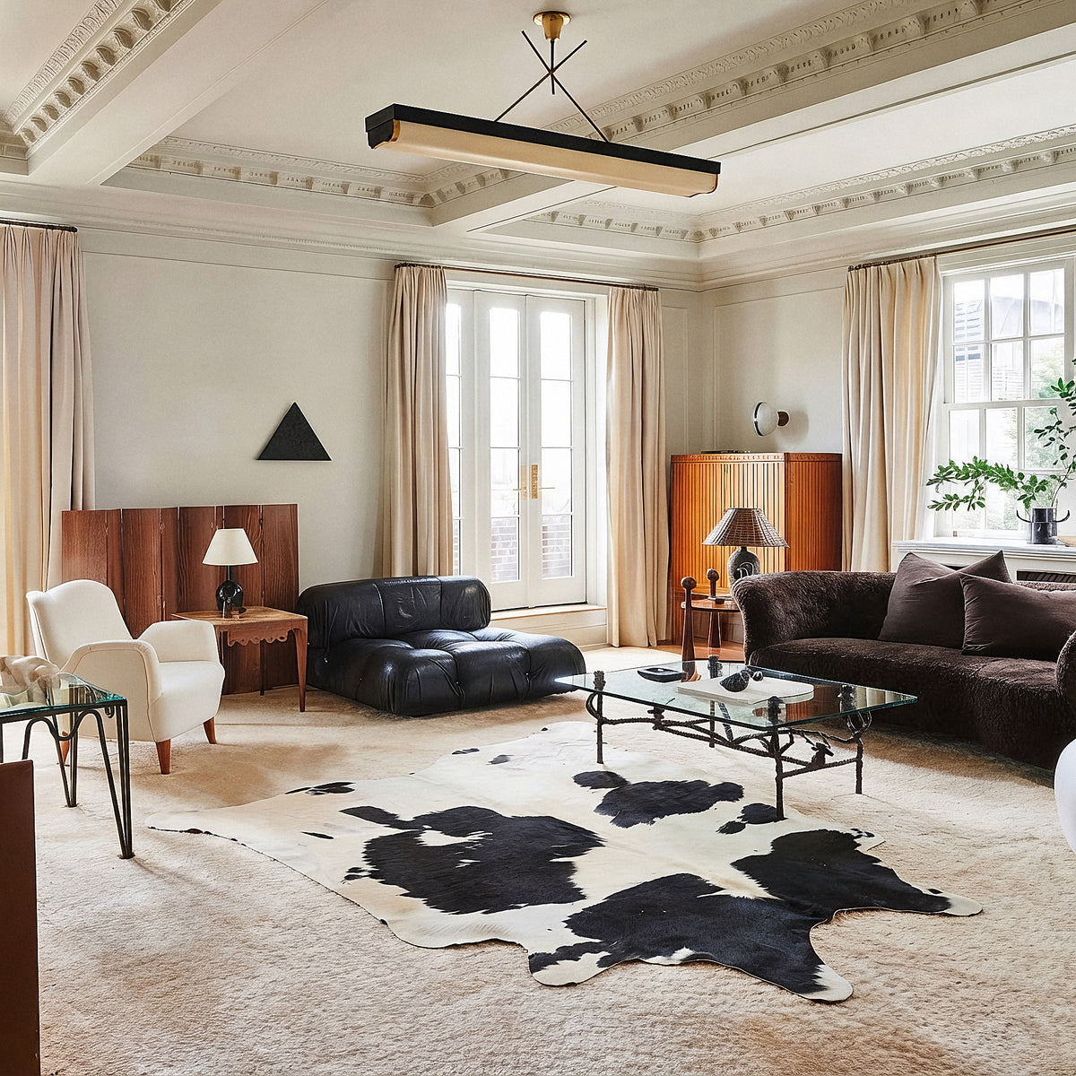 Black and white cowhide rug in a herringbone-floored dining nook