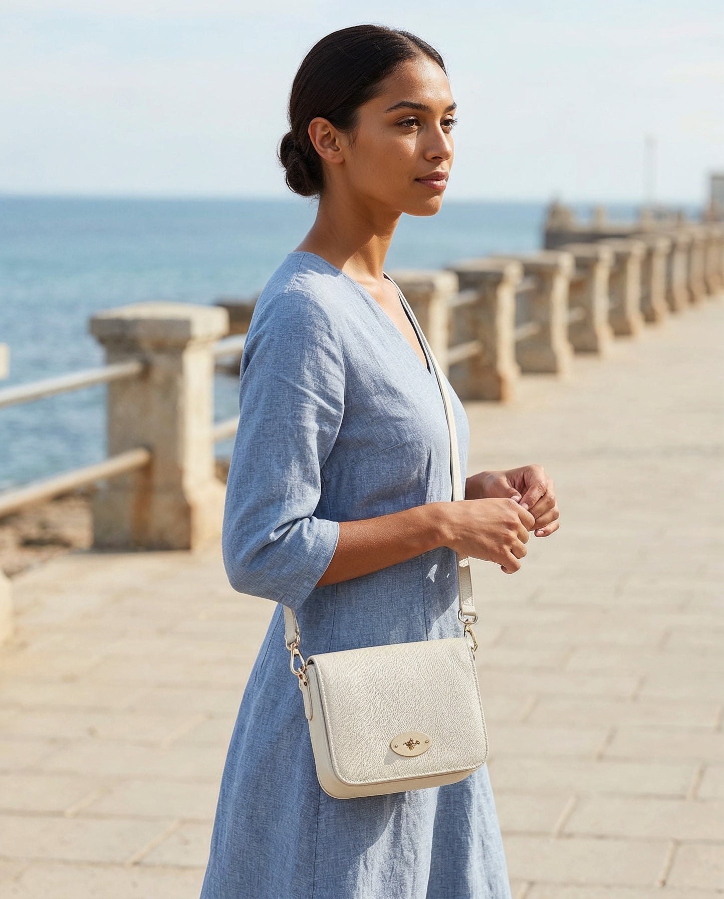 Woman with the Oyster Chiara crossbody bag on a seaside promenade