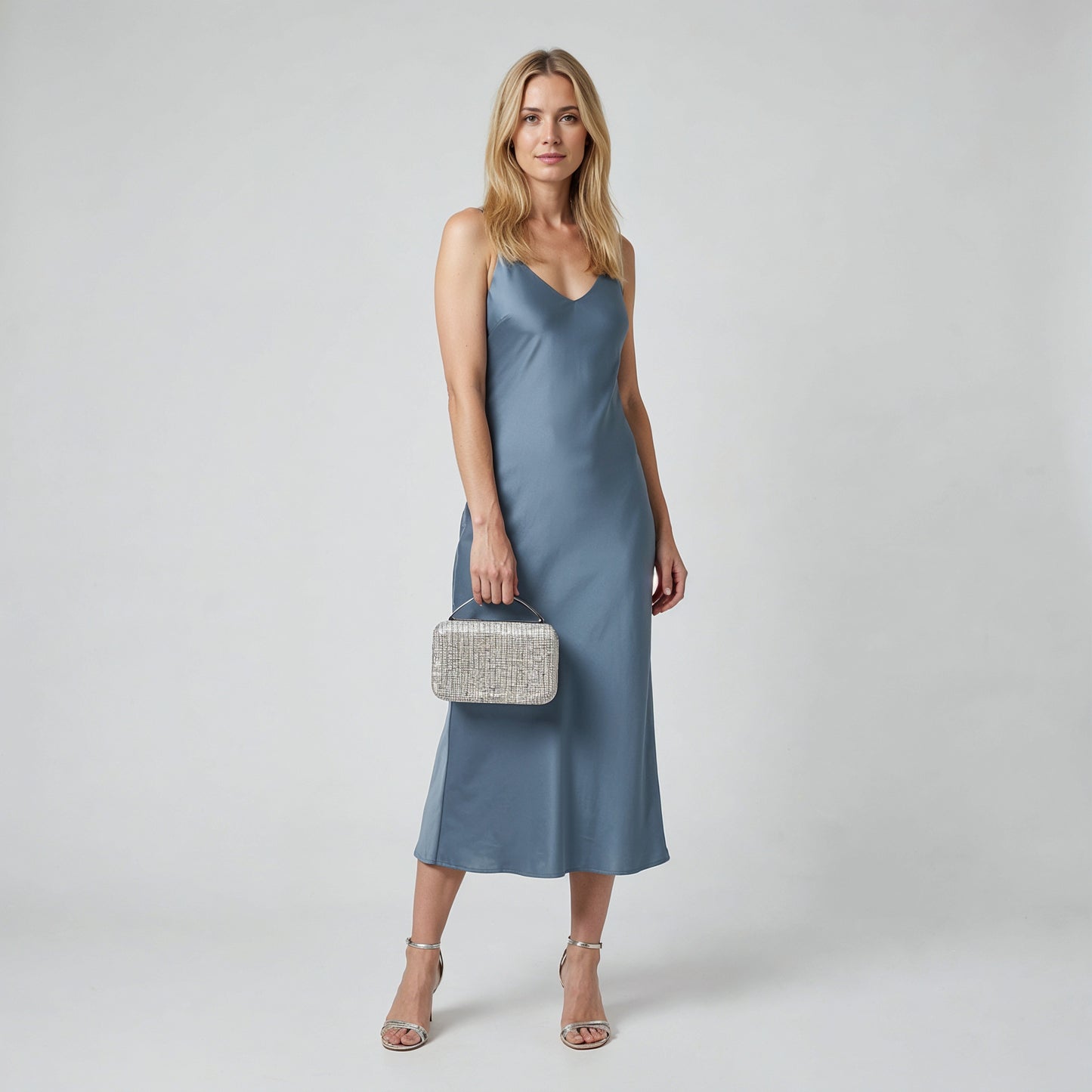 Model holding the Silver Odette Crystal Minaudière Clutch by its top handle, studio shot