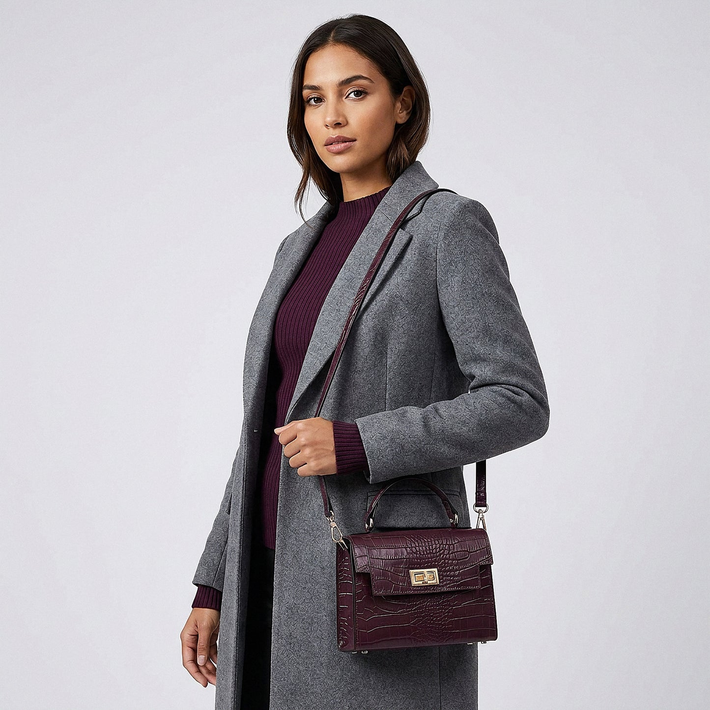 Model carrying the Aubergine Margot Croc crossbody bag on her shoulder, studio shot