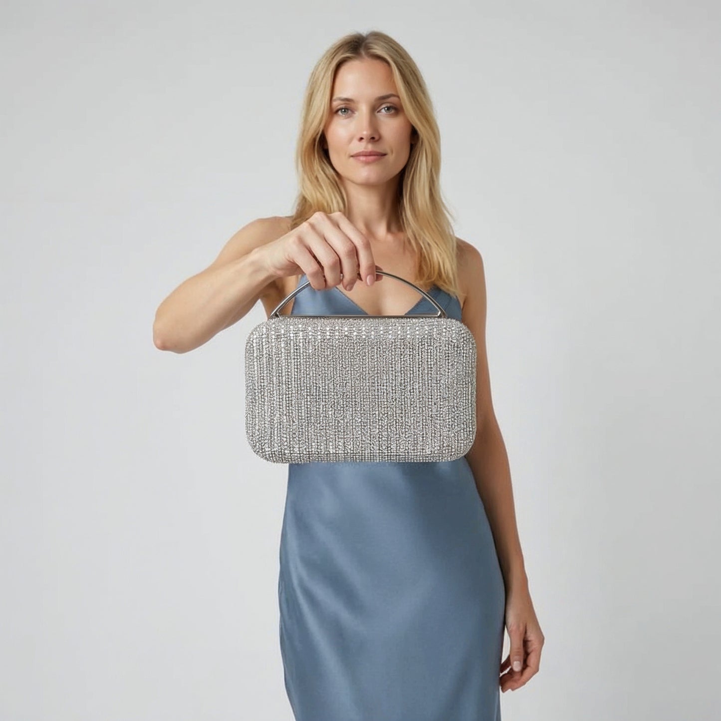 Model with the Silver Odette Crystal Minaudière Clutch dangling from her fingers, studio shot
