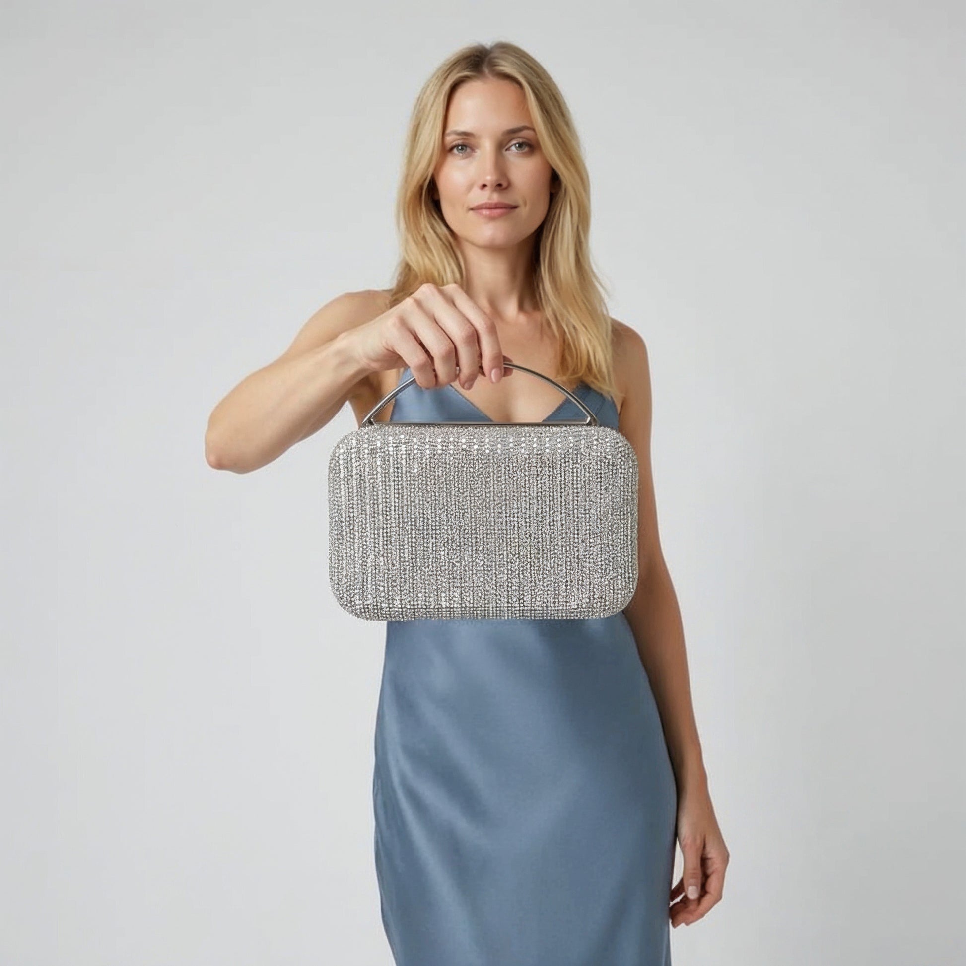 Model with the Silver Odette Crystal Minaudière Clutch dangling from her fingers, studio shot