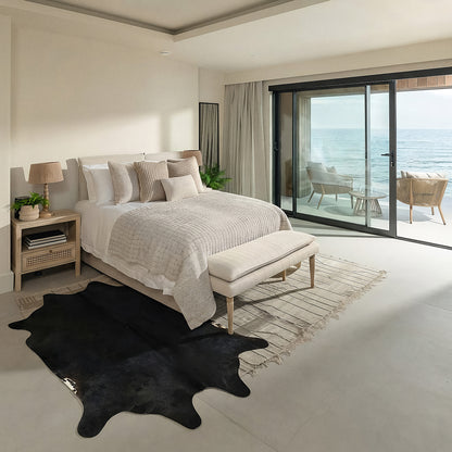Black cowhide rug in a coastal ocean-view bedroom