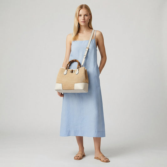 Model wearing the White Ginevra Bamboo-Handle Raffia Bag by Clemés crossbody, studio shot