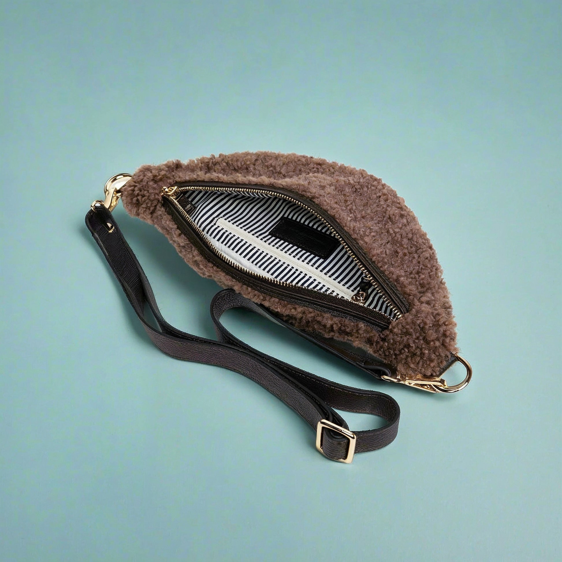 Nevina shearling and leather bum bag on a teal studio background