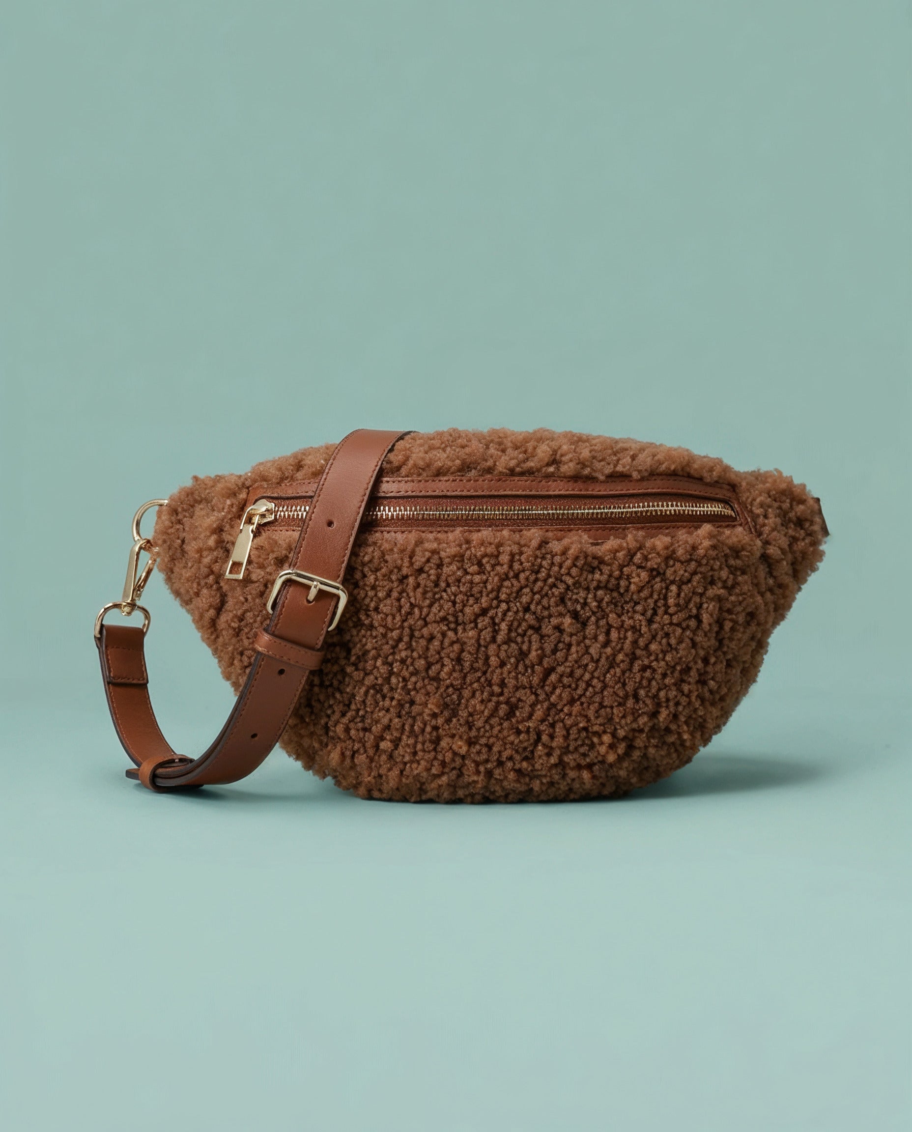 Nevina shearling and leather bum bag on a teal studio background