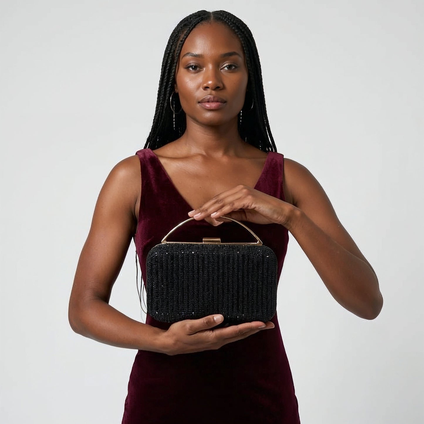 Model presenting the Black Odette Crystal Minaudière Clutch on her open palm, studio shot