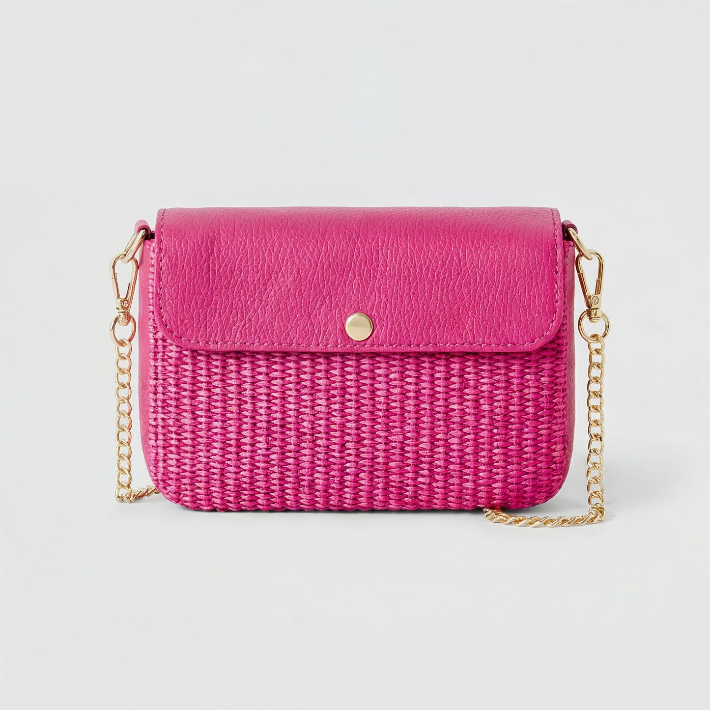 Élodie raffia and leather flap crossbody bag in fuchsia on a light grey studio background