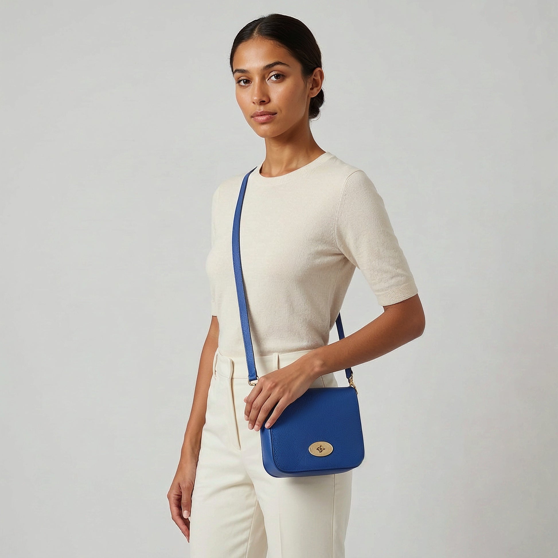 Model with the Royal Blue Chiara crossbody bag at her hip, studio shot