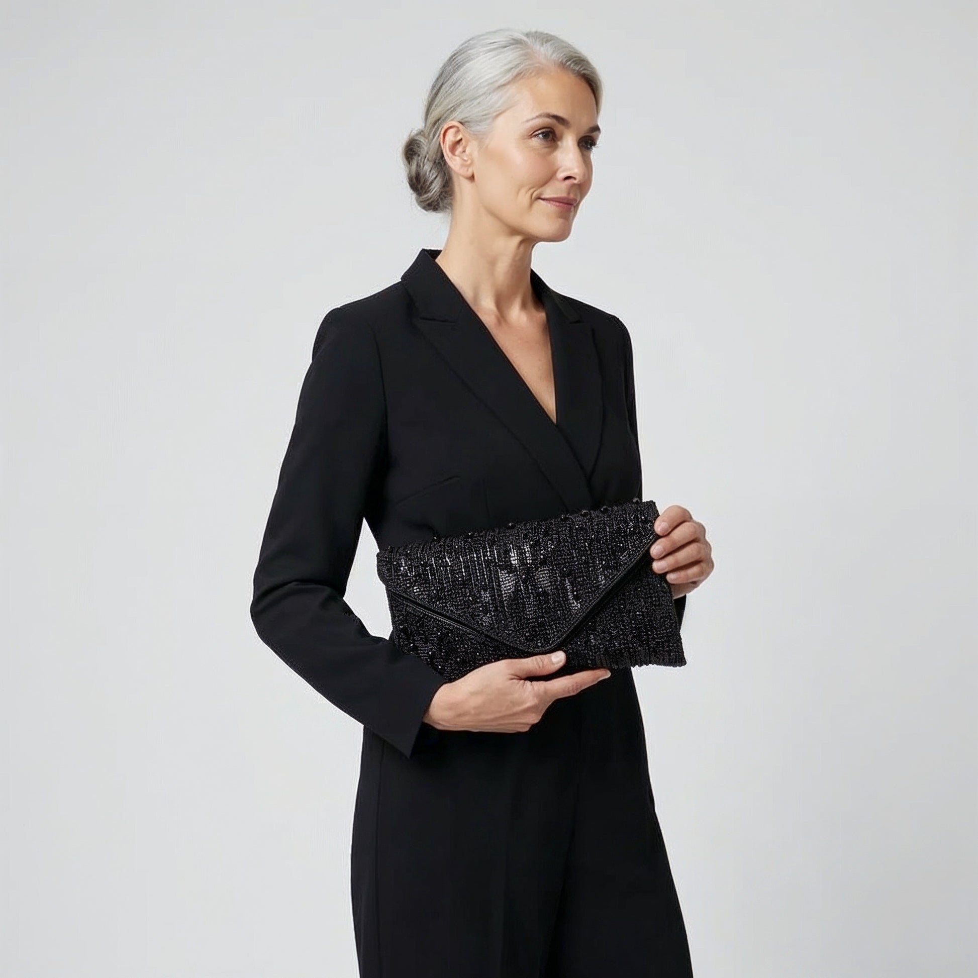 Model holding the Black Perlette Pearl & Crystal Envelope Clutch in both hands, studio shot