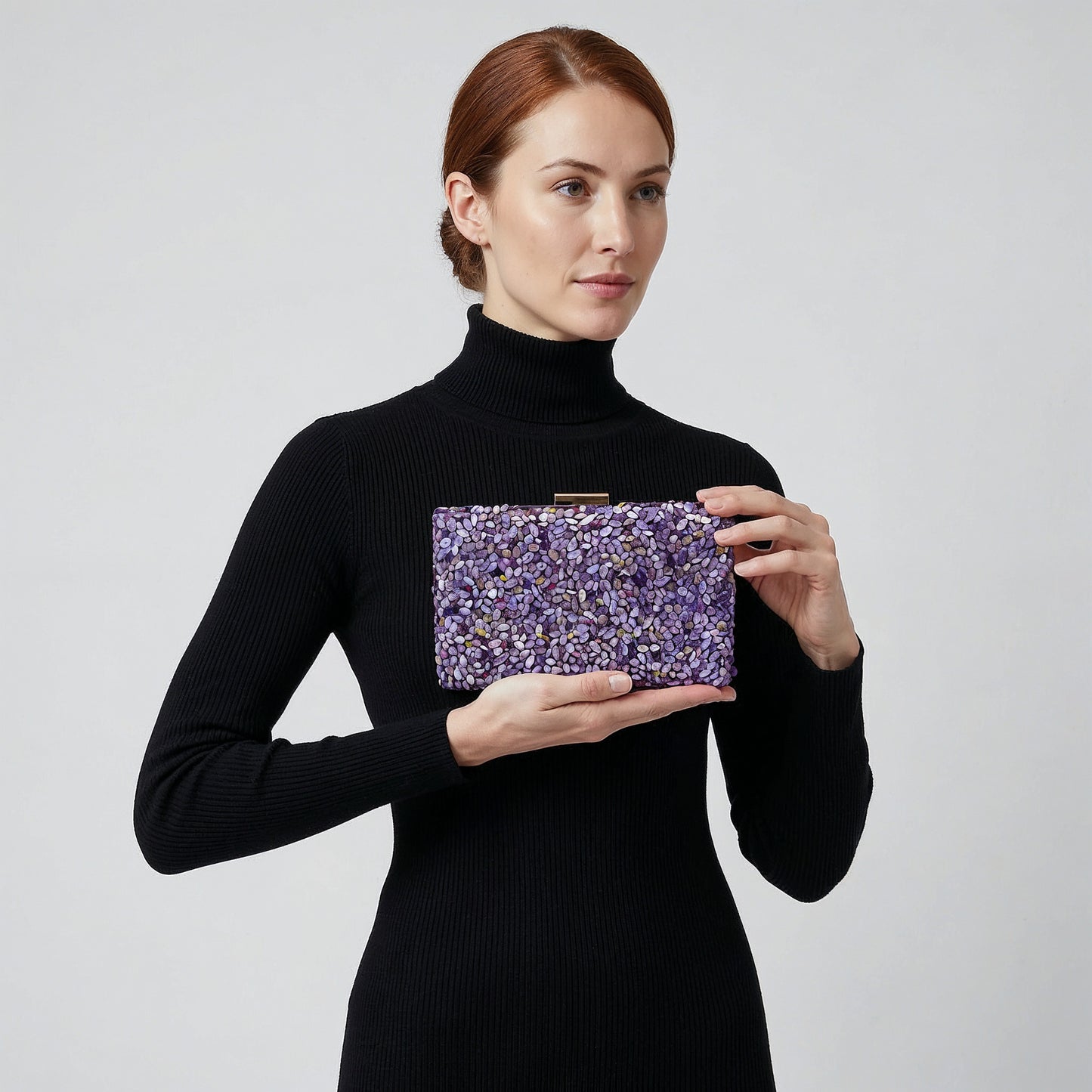 Model presenting the Violet Gemma Natural Stone Box Clutch on her open palm, studio shot