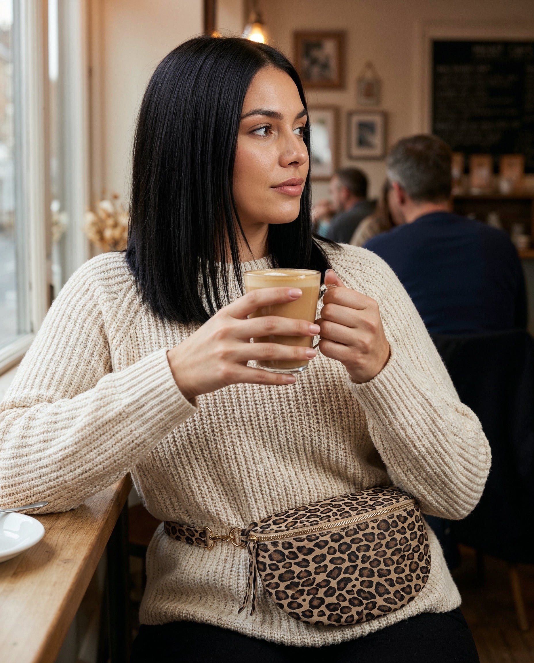 Woman with the Matt Light Taupe Leopard Romy bum bag at a cafe window seat