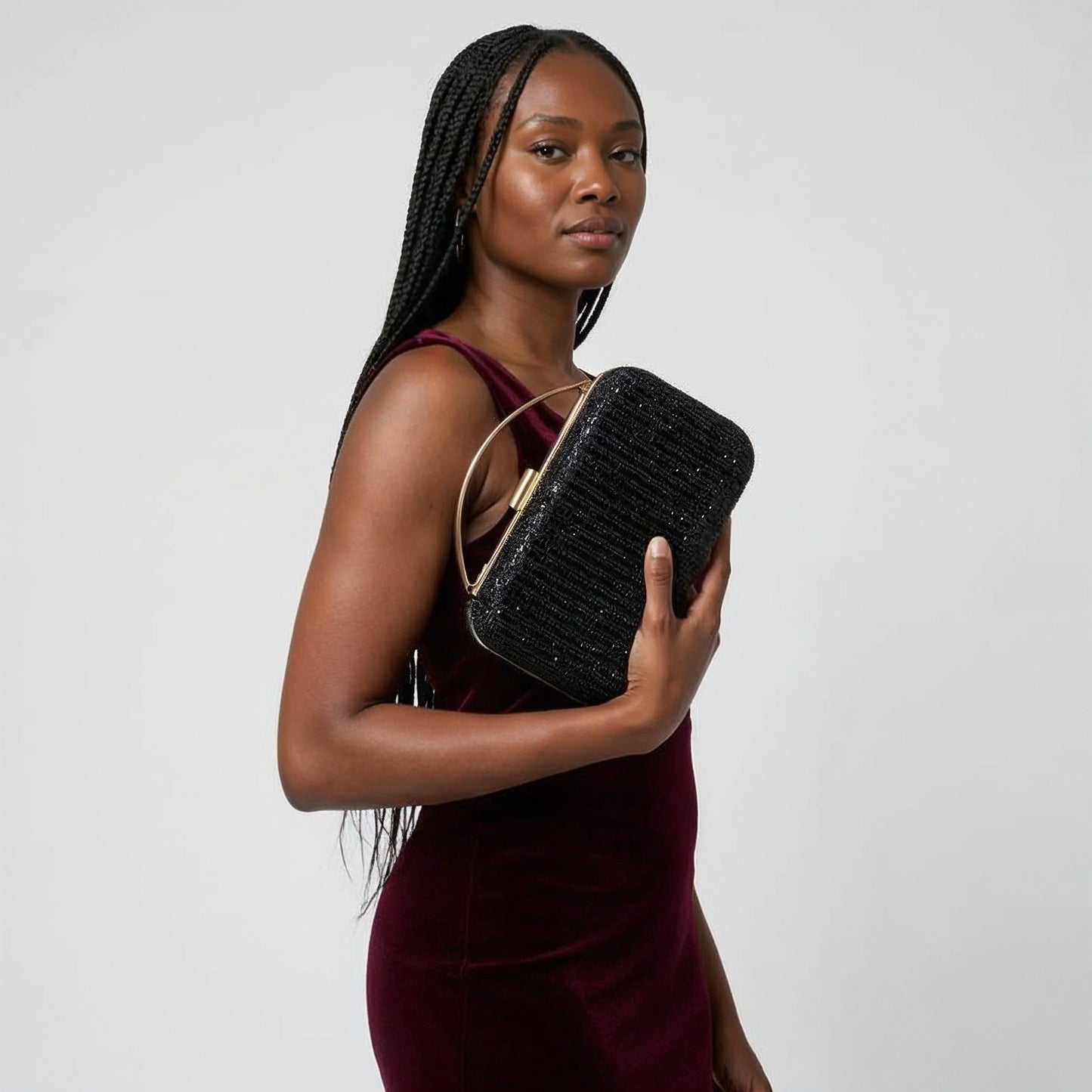 Model with the Black Odette Crystal Minaudière Clutch under her arm, studio shot