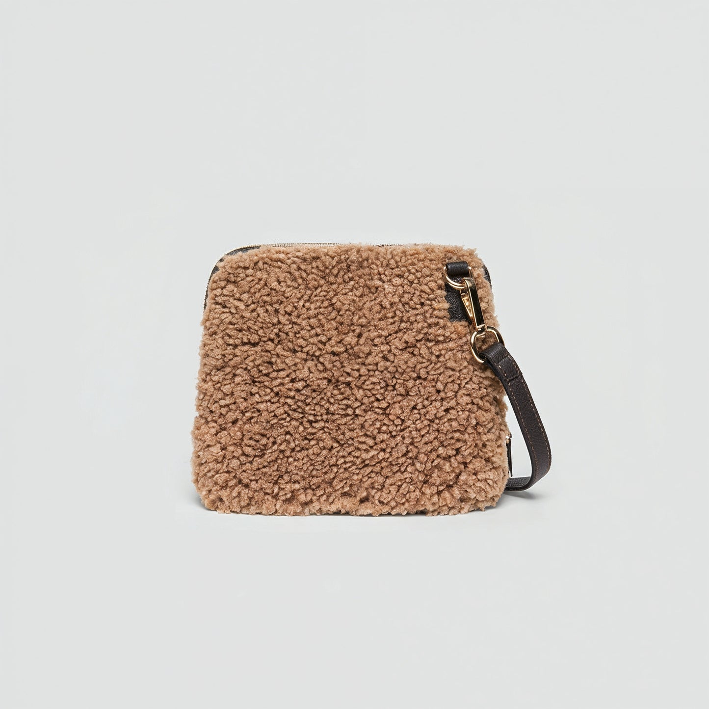 Zita faux shearling crossbody bag in tan on a light grey studio background
