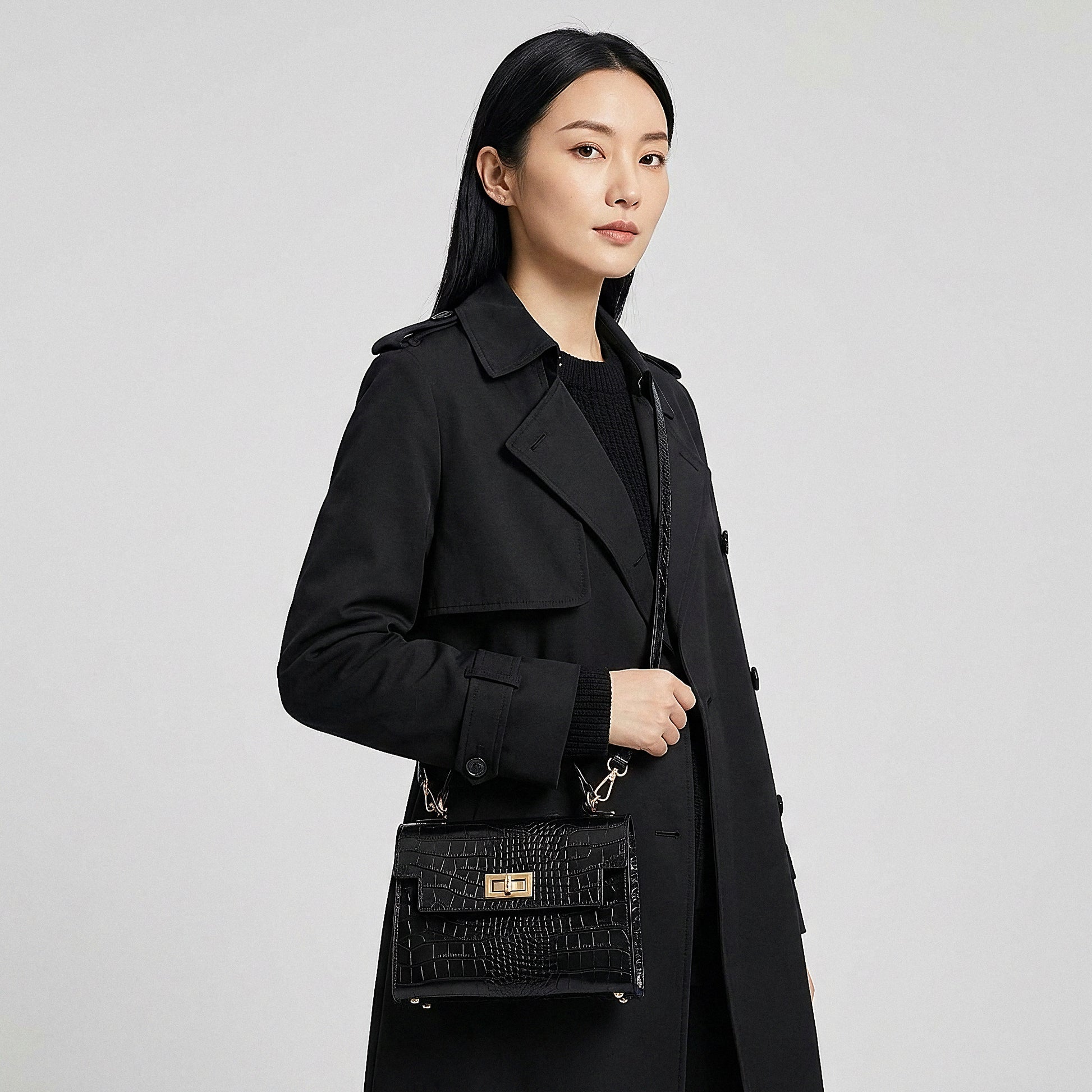 Model carrying the Black Margot Croc crossbody bag on her shoulder, studio shot