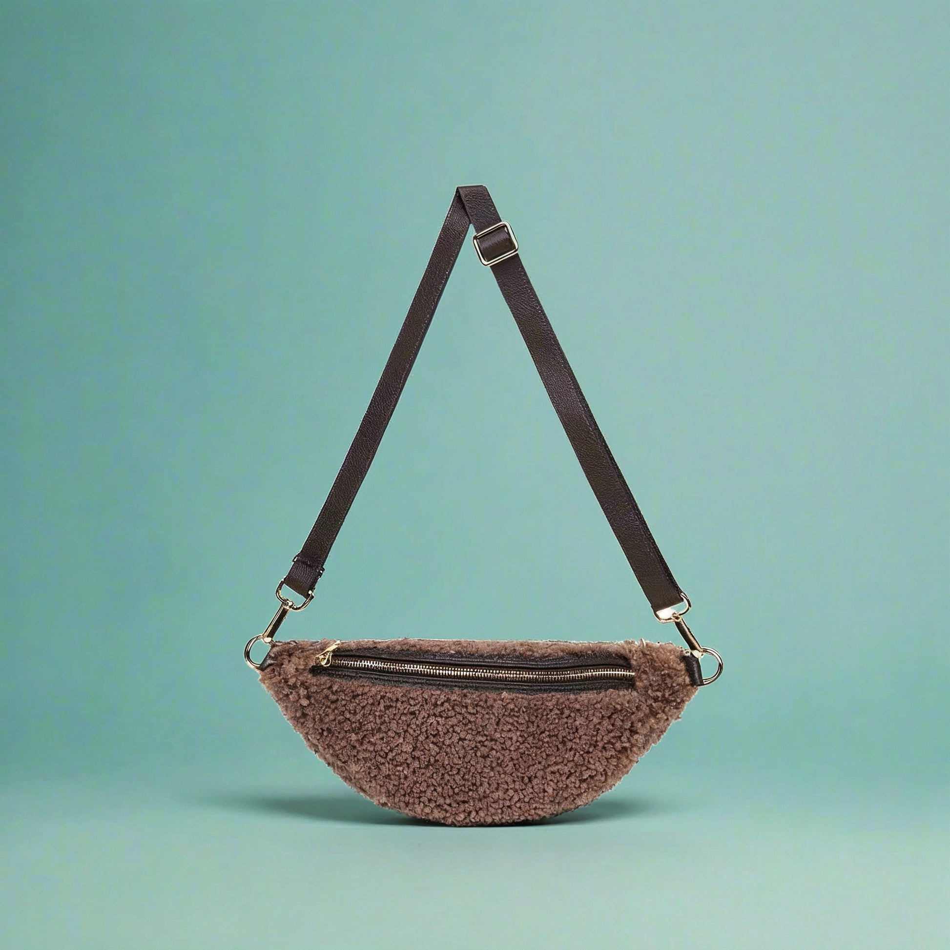 Nevina shearling and leather bum bag on a teal studio background