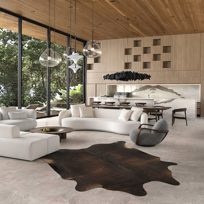 Dark chocolate cowhide rug styled on the floor of a dark academia living room